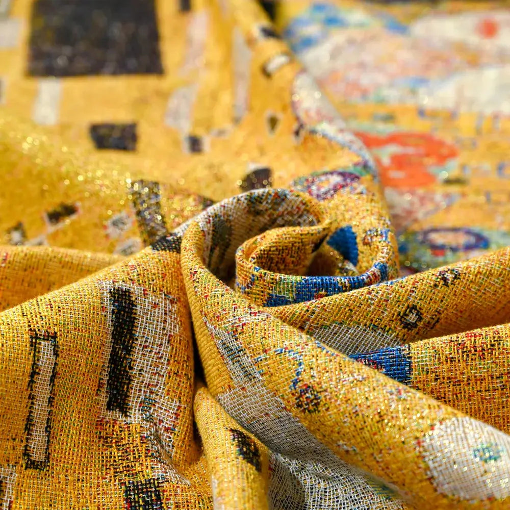 A vibrant yellow woven tapestry bedroom blanket with gustav klimt kiss art pattern and gold black blue accents from decorbites