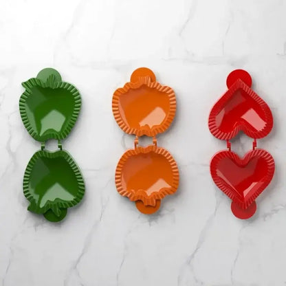 Set of three colorful glossy plastic hand pie molds shaped like apples and hearts for Halloween baking
