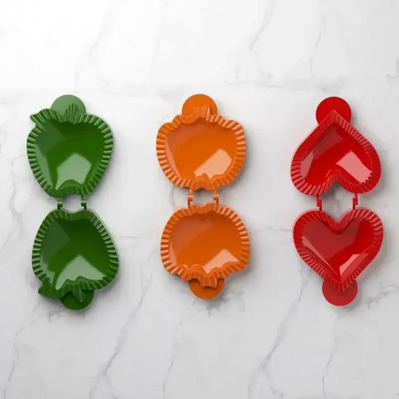 Set of three colorful glossy plastic hand pie molds shaped like apples and hearts for Halloween baking