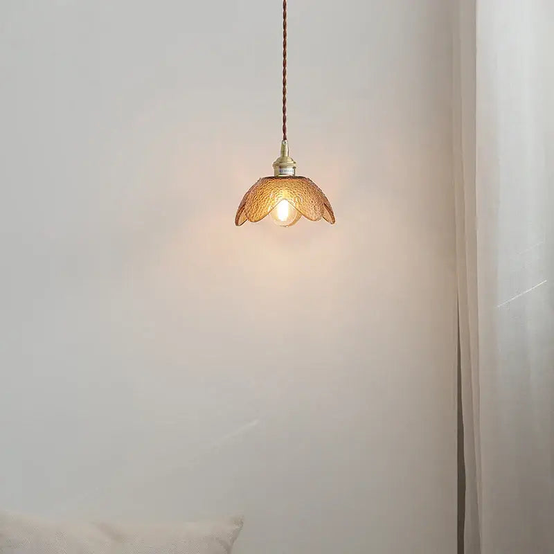 Warm-toned amber glass led pendant light with delicate petal design and brass hardware for kitchen lighting
