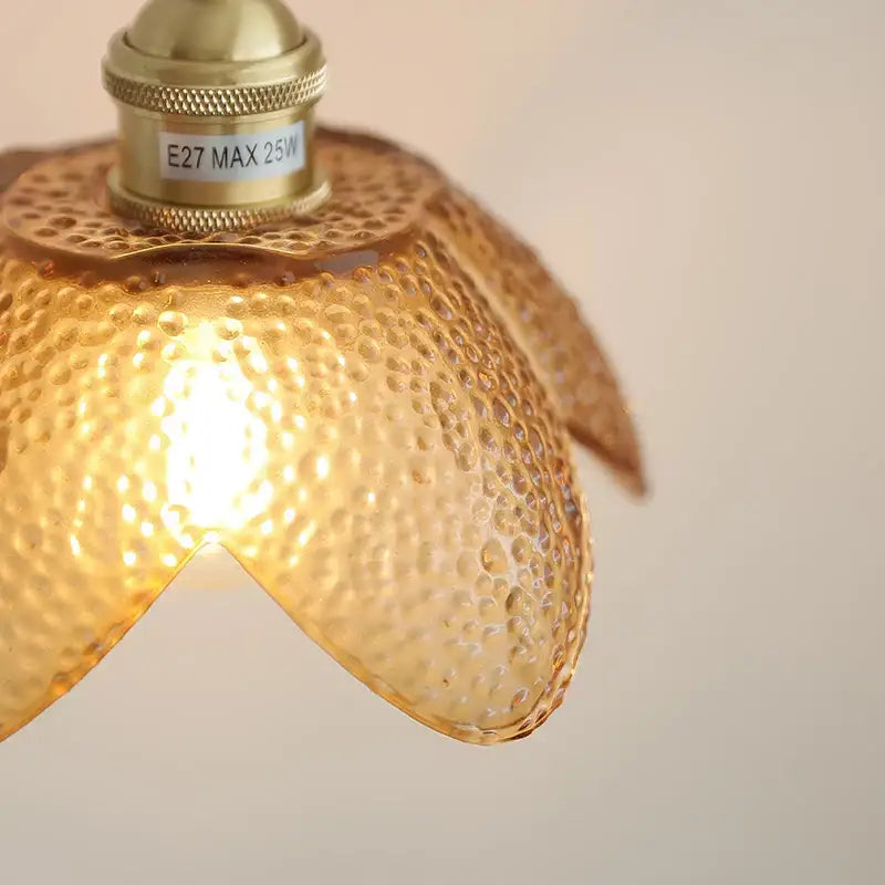 Gold-toned hammered amber glass led pendant light with textured petal design and brass-finished fixture for kitchen use