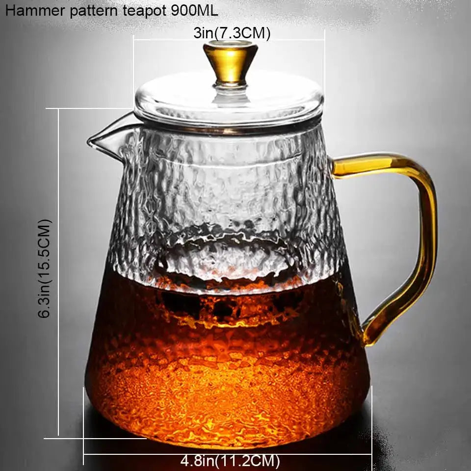 Clear borosilicate glass teapot with hammered texture and gold-toned handle filled with amber tea for kitchen use