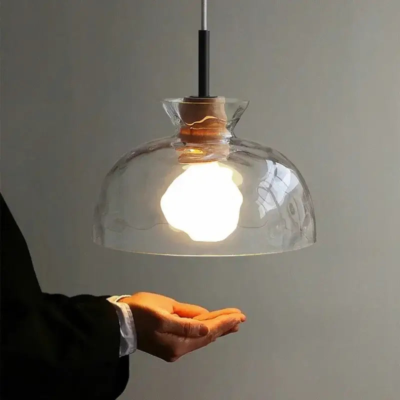 Clear glass pendant light with a textured dome shade and natural wood cork accent for kitchen decorbites clear glass design