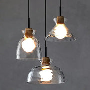 Three clear glass pendant lights with hammered texture cork accents and black cords for kitchen decorbites clear glass