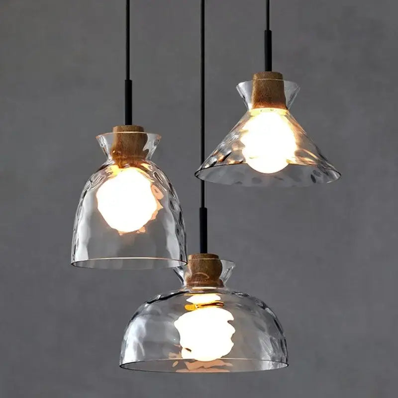 Three clear glass pendant lights with hammered texture cork accents and black cords for kitchen decorbites clear glass