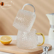 Hammered clear glass water cup with textured finish and gold-tone handle ideal for kitchen use