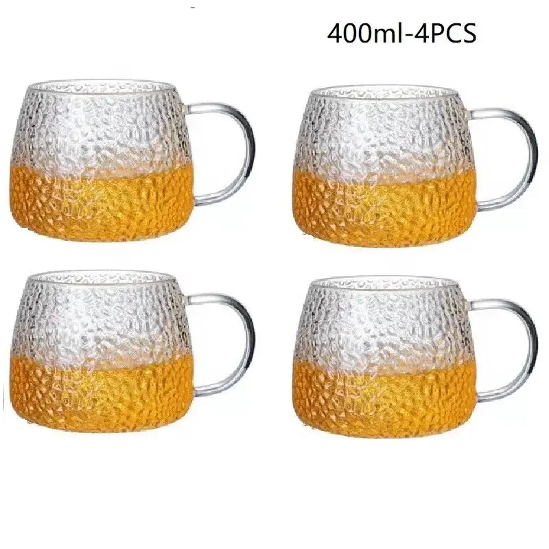 Clear glass water cup with hammered finish amber lower half and gold handle for kitchen use