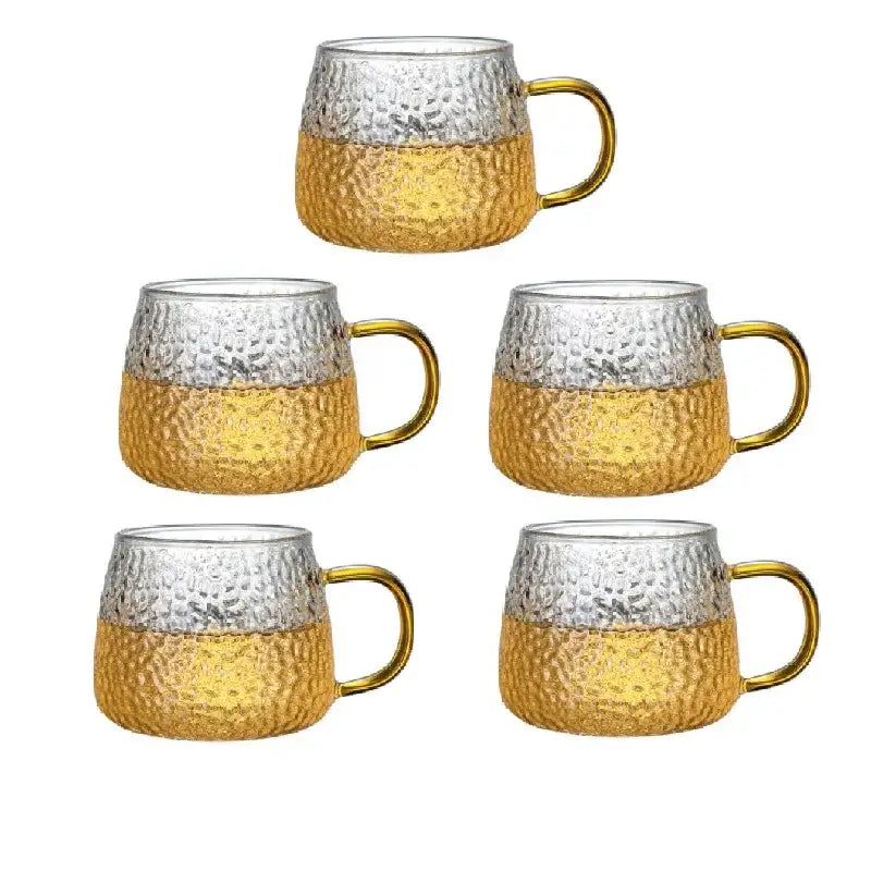 Set of five hammered glass water cups with clear upper half golden lower half and gold-toned handles for kitchen use