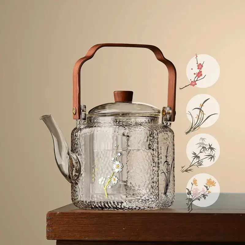 Clear glass teapot with hammered texture and hand-painted floral bamboo design featuring wooden lid and bronze handle decorbites glass teapot