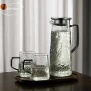 Clear glass water pitcher with hammered textured surface and black metal handle by decorbites gray amber for kitchen use