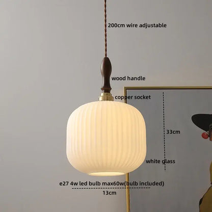 A warm softly glowing pendant lamp with white ribbed glass shade and copper wire for living room lighting