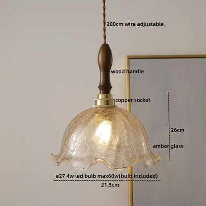 A warm amber glass led pendant lamp with textured crackled finish and wooden handle for living room lighting