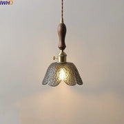 A warm-toned hammered gray glass led pendant lamp with dark wood handle and brass accents for living room lighting