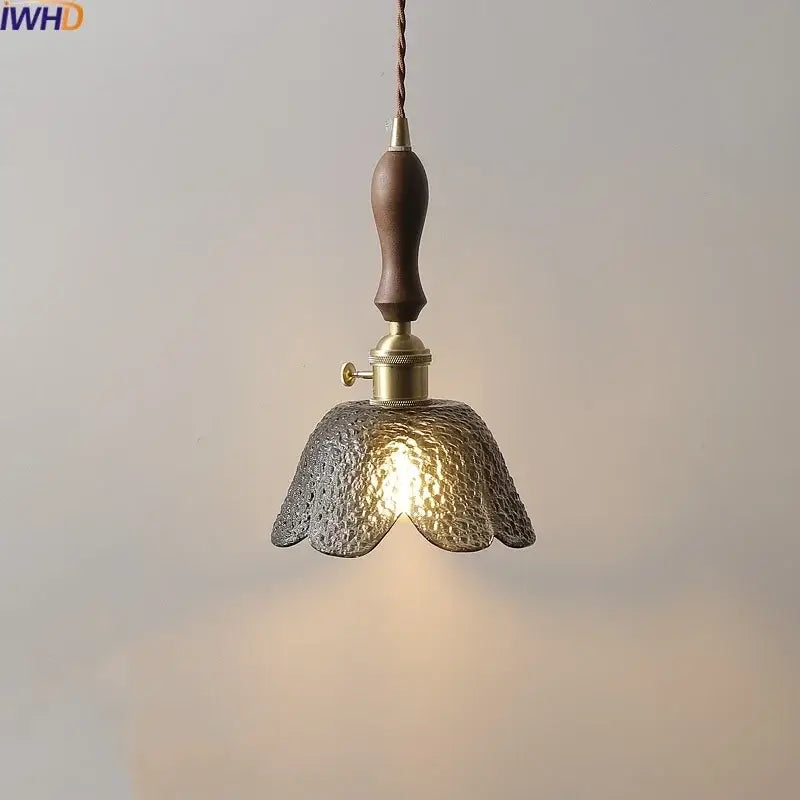 A warm-toned hammered gray glass led pendant lamp with dark wood handle and brass accents for living room lighting