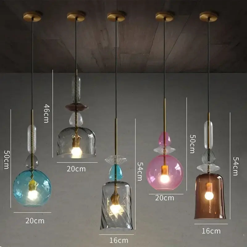 Five colorful hand-blown decorbites candy glass pendant lights with brass accents in blue pink amber and clear hues for dining room decor