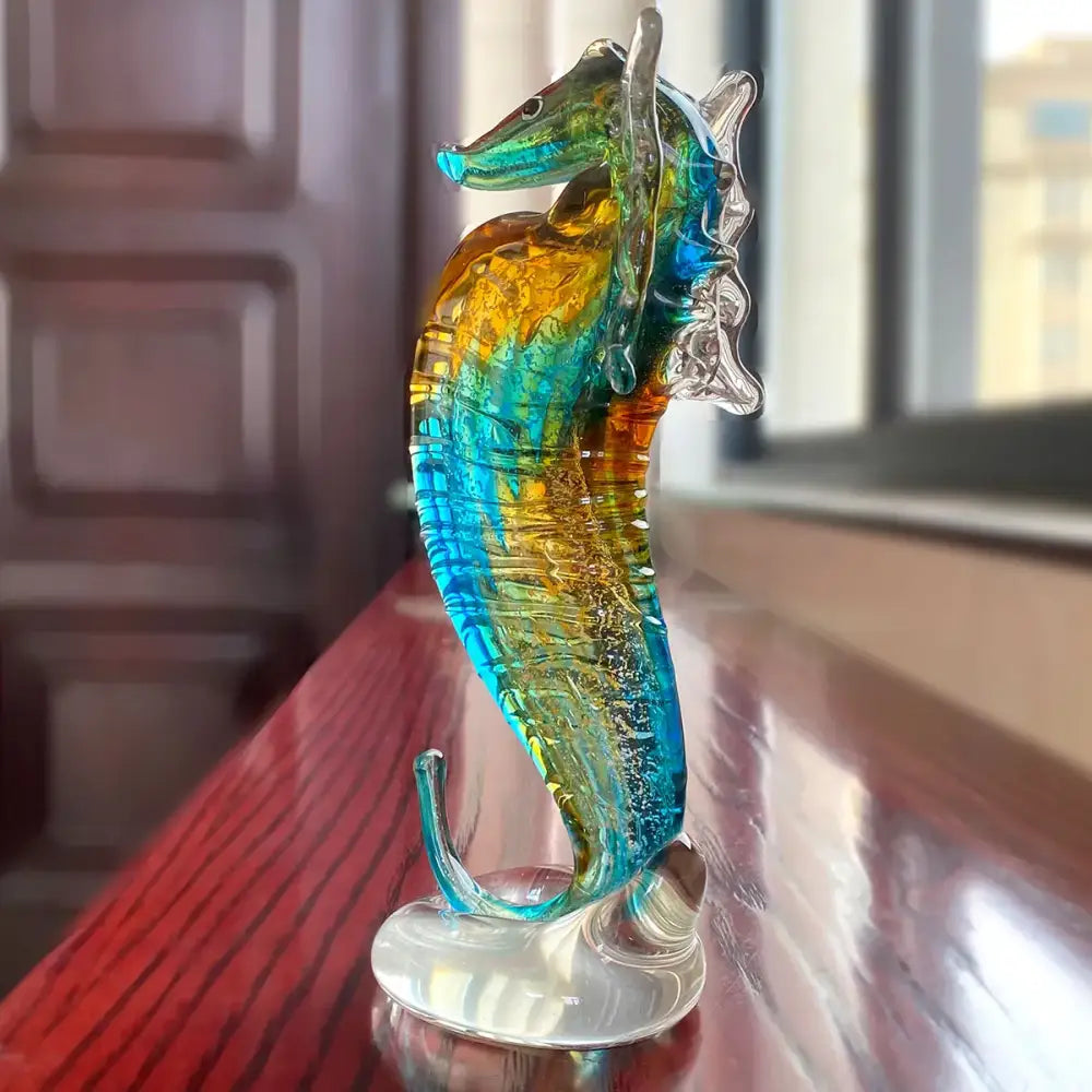 A vibrant hand blown glass seahorse figurine with swirling blue and amber hues for living room decor