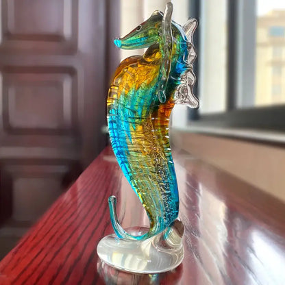 A vibrant hand blown glass seahorse figurine with swirling blue and amber hues for living room decor