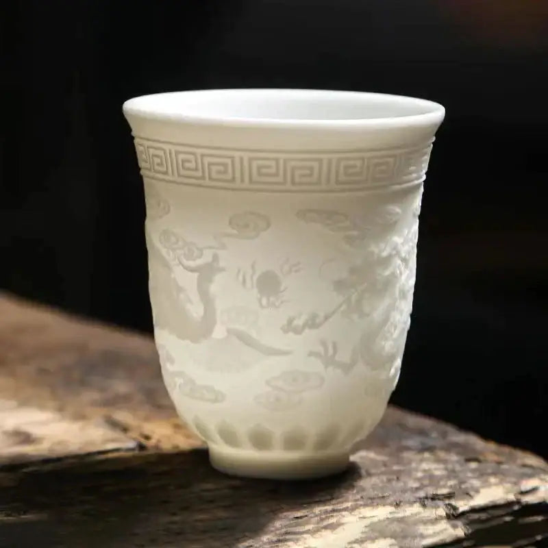 Delicate white porcelain tea cup set featuring embossed dragon cloud motifs and greek key pattern for dining room use
