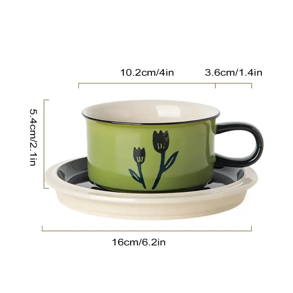 Green ceramic espresso cup with hand-drawn black tulip design and matching saucer dining room set