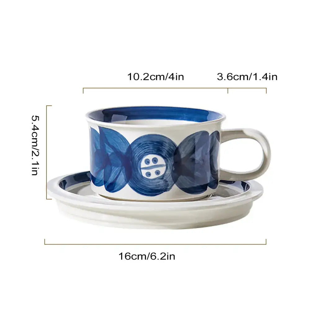 White ceramic espresso cup and saucer set with blue hand-painted leaf floral and button-like patterns for dining room use