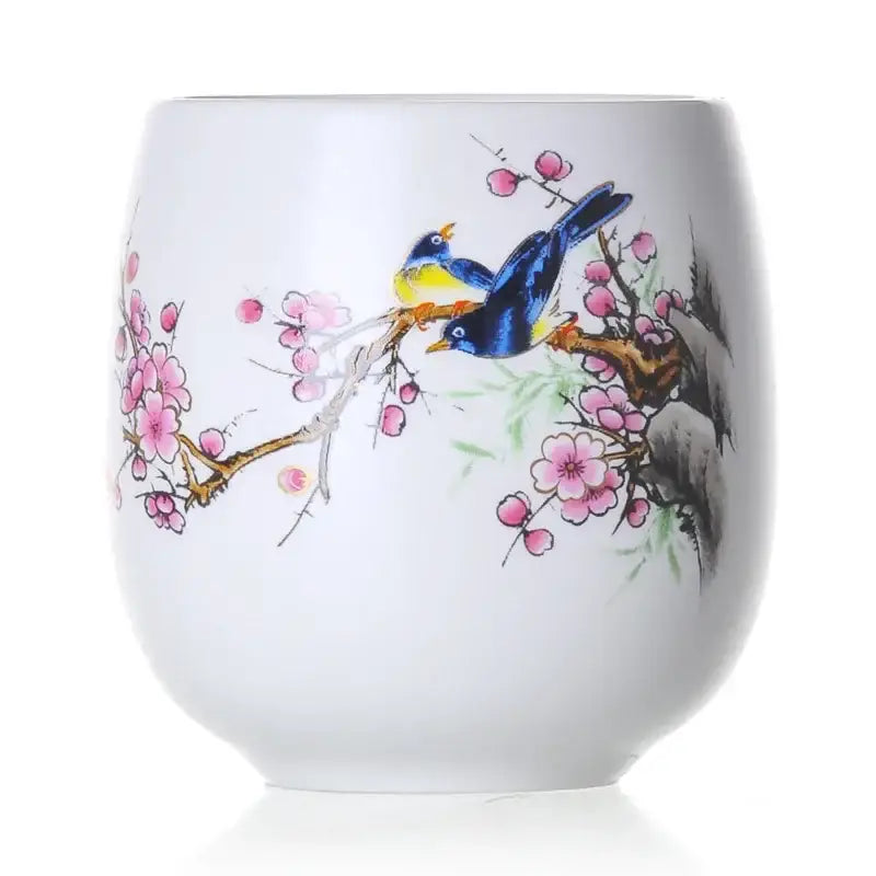 Hand-painted floral white porcelain kung fu tea cup with blue and yellow birds on pink cherry blossoms decorbites ceramic kung