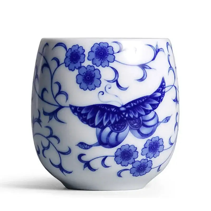 A white ceramic kung fu tea cup with hand-painted blue floral and butterfly patterns ideal for dining room use