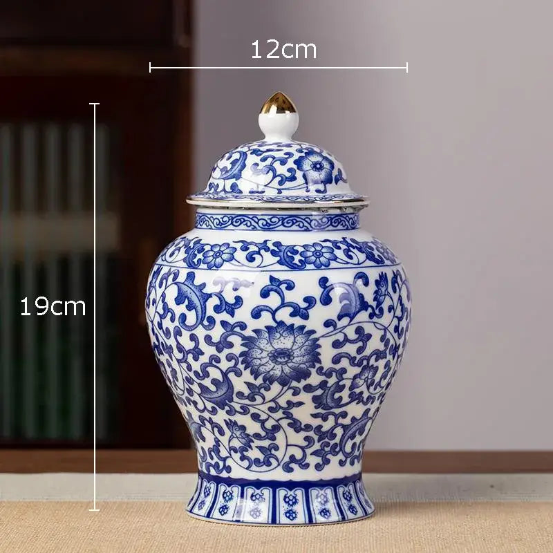 Hand-painted white porcelain tea canister with blue floral patterns and a gold-tipped lid for kitchen storage