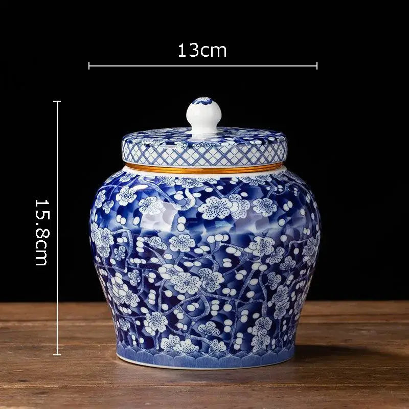 Hand-painted white porcelain tea canister with blue floral designs and a lattice-patterned lid for kitchen storage