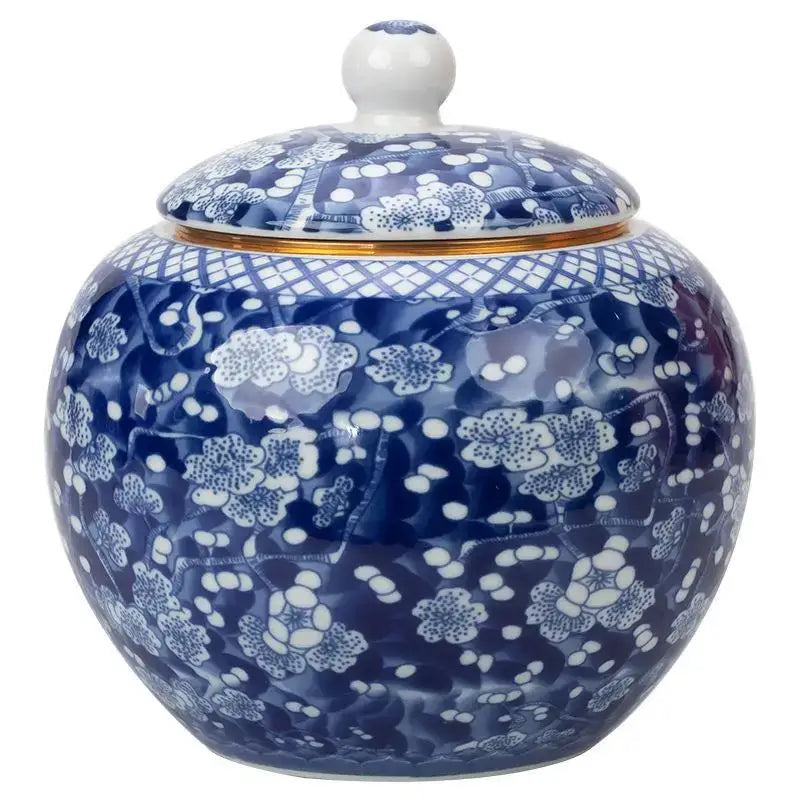 Hand-painted white porcelain tea canister with blue floral patterns and gold-trimmed lid for kitchen storage
