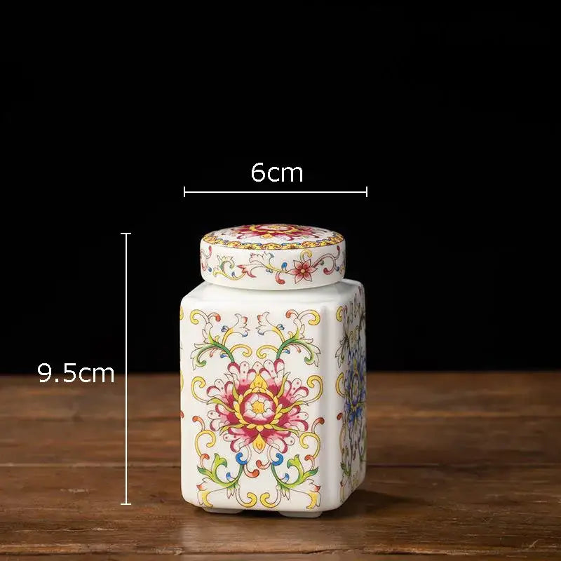 White porcelain tea canister with matching lid hand-painted with vibrant pink yellow and green floral patterns