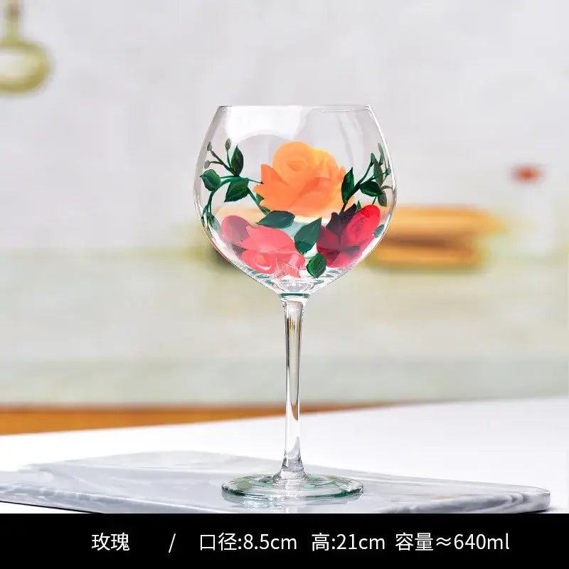 A clear decorbites crystal floral wine goblet with hand-painted orange red and pink roses and green leaves