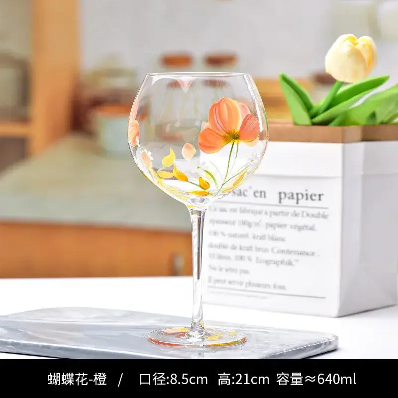 A clear glass decorbites crystal floral wine goblet with hand-painted orange and yellow flowers for dining room use