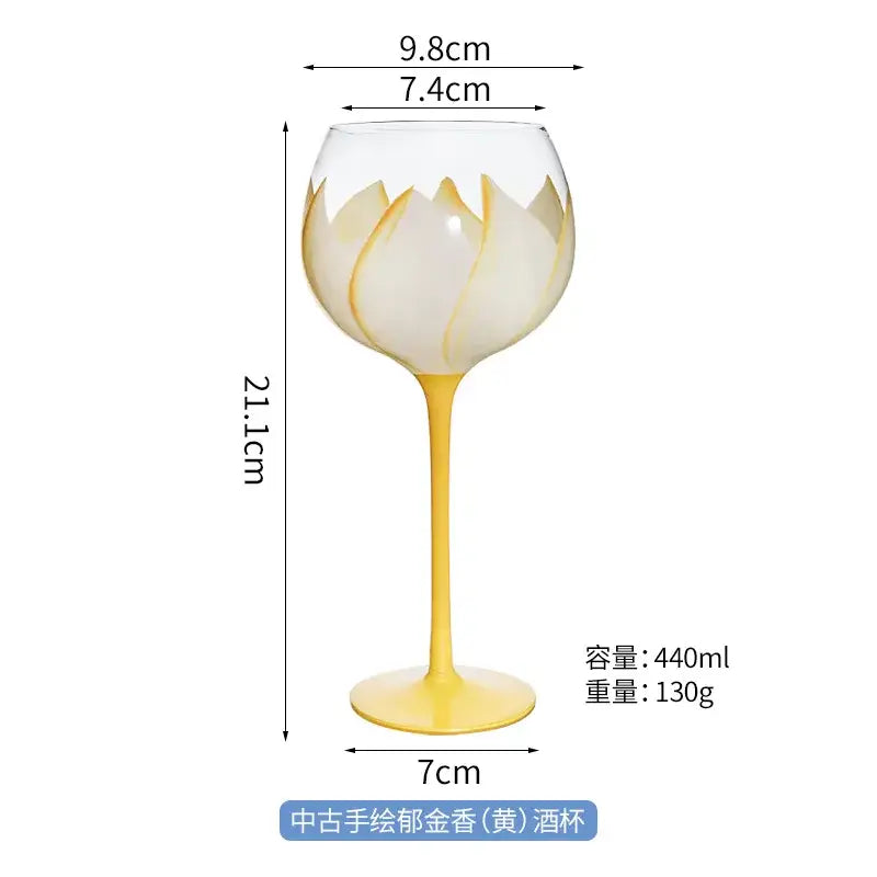 Delicate yellow-handled hand painted glass goblet with white lotus design and gold accents for floral dining decor