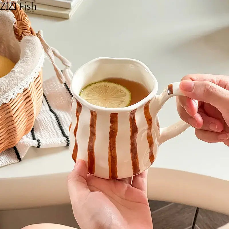 A hand-painted porcelain mug with colorful stripes and a lemon slice in a warm beverage from decorbites colorful stripes set