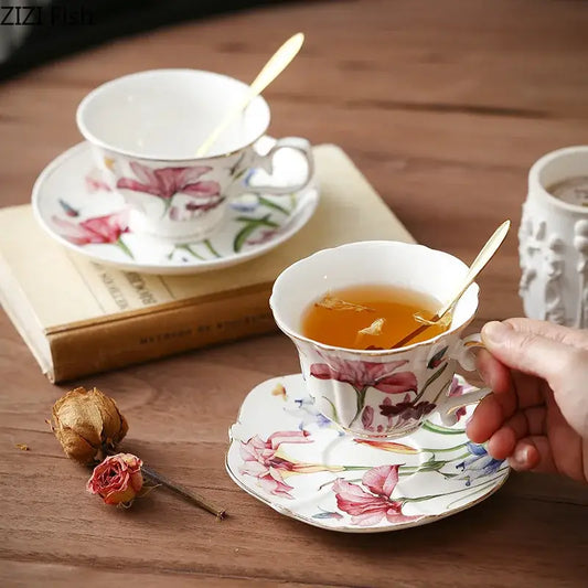 A delicate iris flower porcelain tea cup with hand-painted pink and purple floral patterns and gold trim decorbites iris flower