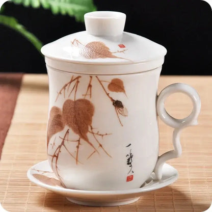 Hand painted lotus white porcelain tea cup with filter and matching lid and saucer featuring brown leaf designs and calligraphy