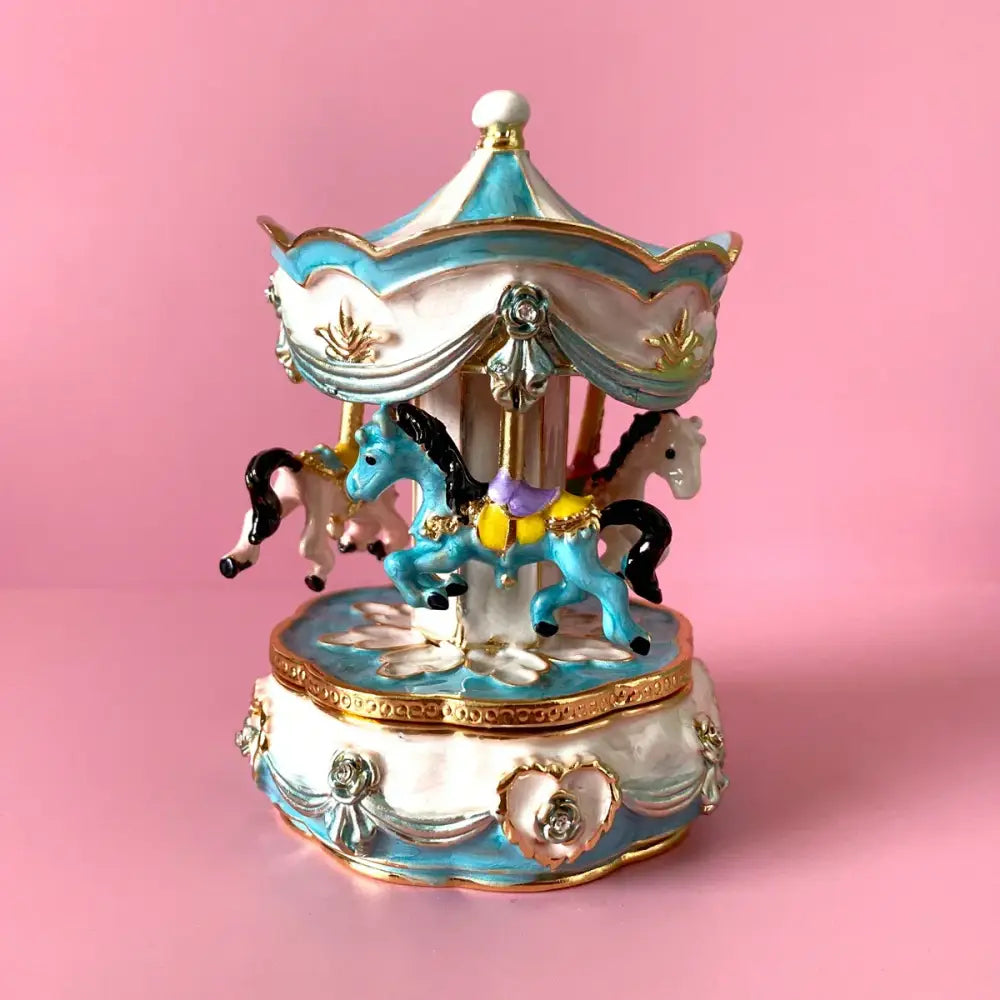 Hand painted pastel blue and white porcelain carousel horse trinket box with gold accents and miniature horses in motion