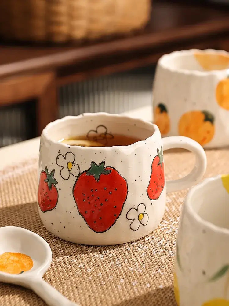 Hand-painted strawberry cartoon fruit ceramic mug with red berries white flowers and speckled white ceramic finish