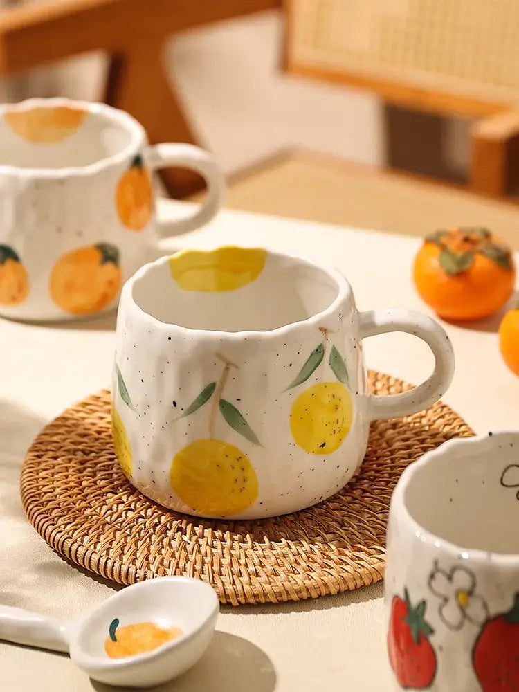 White ceramic cartoon fruit ceramic mug with hand-painted yellow lemons and green leaves speckled texture for kitchen use