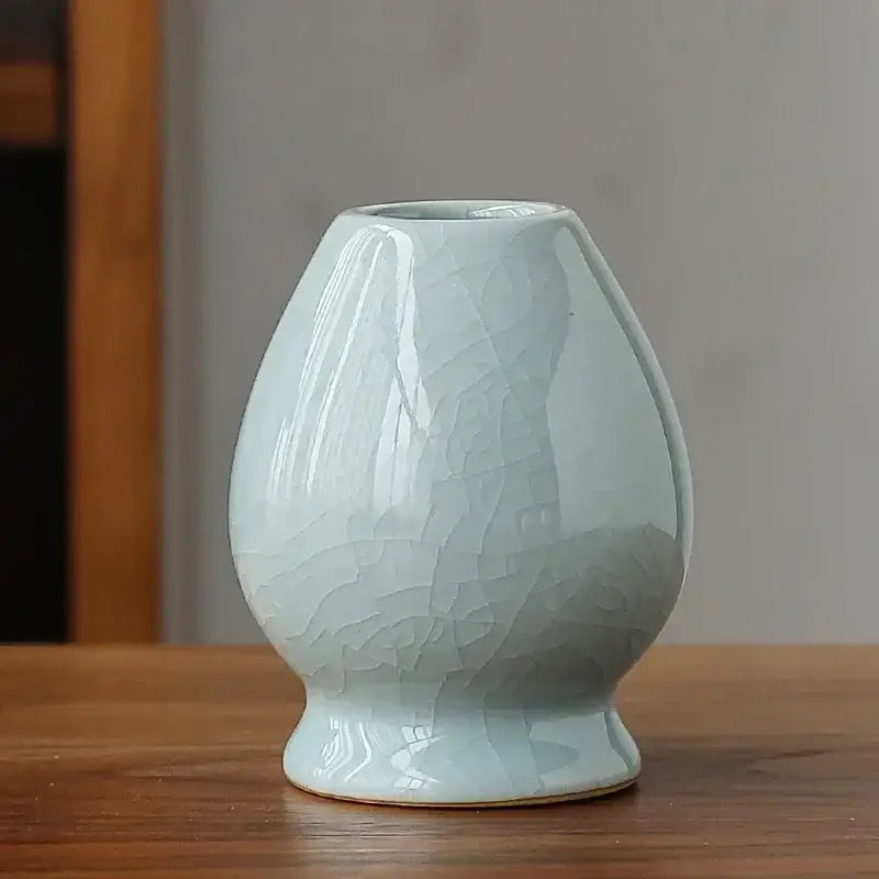 Delicate celadon ceramic pear-shaped whisk holder stand with subtle crackle glaze for matcha whisk display and storage