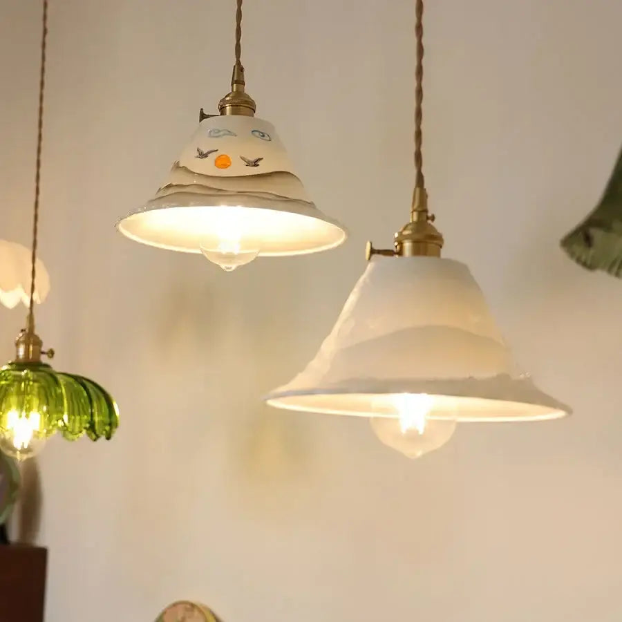 Cream-colored ceramic copper pendant light with hand-painted facial features and brass hardware by decorbites ceramic copper