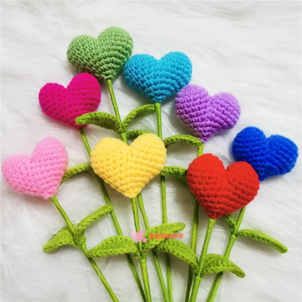 A colorful collection of hand woven love heart yarn crochet flowers in pink red yellow blue purple and green for bedroom decor
