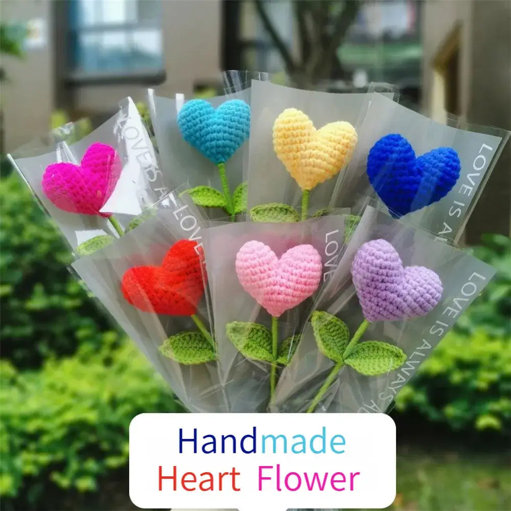 A vibrant hand woven love heart yarn crochet flower bouquet with pink red blue yellow and purple hearts for bedroom decor