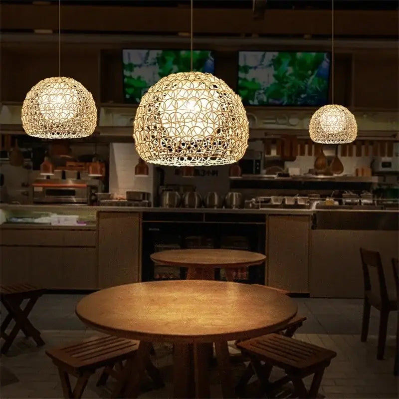 Three hand woven rattan pendant lights with intricate designs emitting warm glow for modern living room chandelier