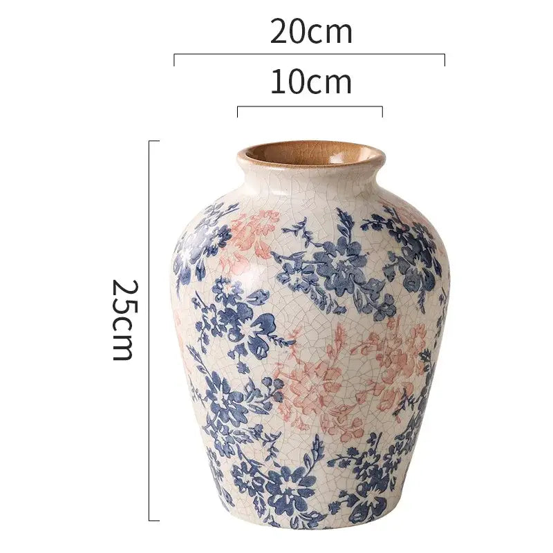 A 25cm tall handcrafted white ceramic vase with crackled cream glaze and blue pink floral decorbites blue patterns