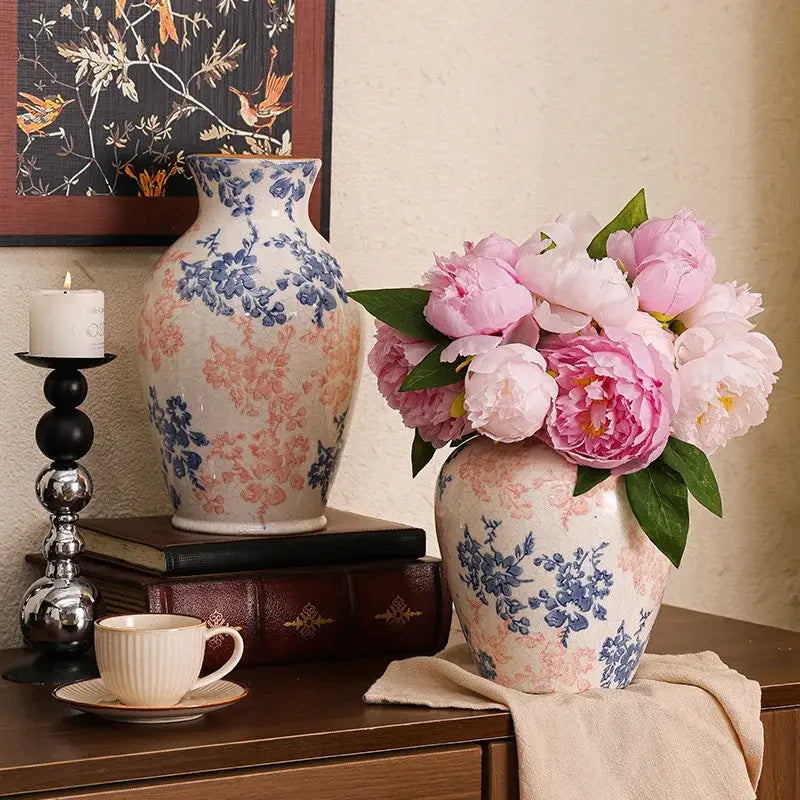 A handcrafted white ceramic vase with delicate blue and pink floral patterns holding pink peonies for living room decorbites decor