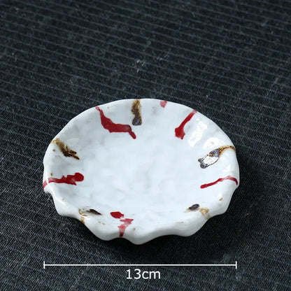 A white ceramic dish with scalloped edge and red brown splatter complements the handcrafted hammer pattern ceramic mug set