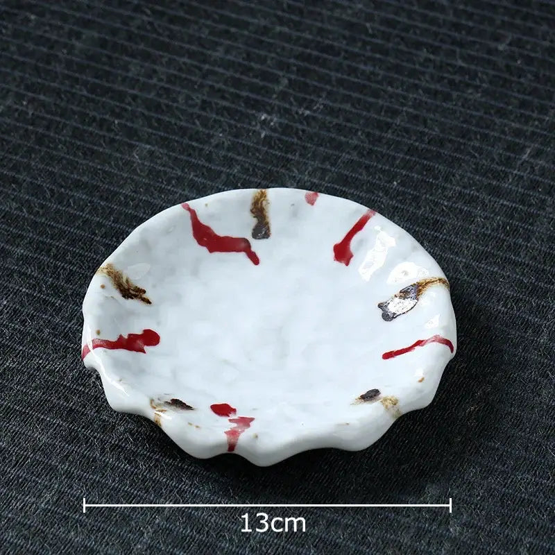 A white ceramic dish with scalloped edge and red brown splatter complements the handcrafted hammer pattern ceramic mug set
