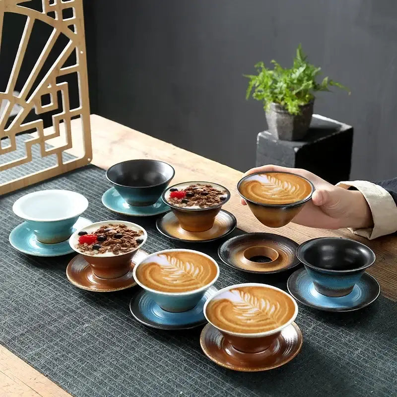 Hand holding a handcrafted brown and amber ceramic latte coffee cup with glossy glaze and latte art in dining room