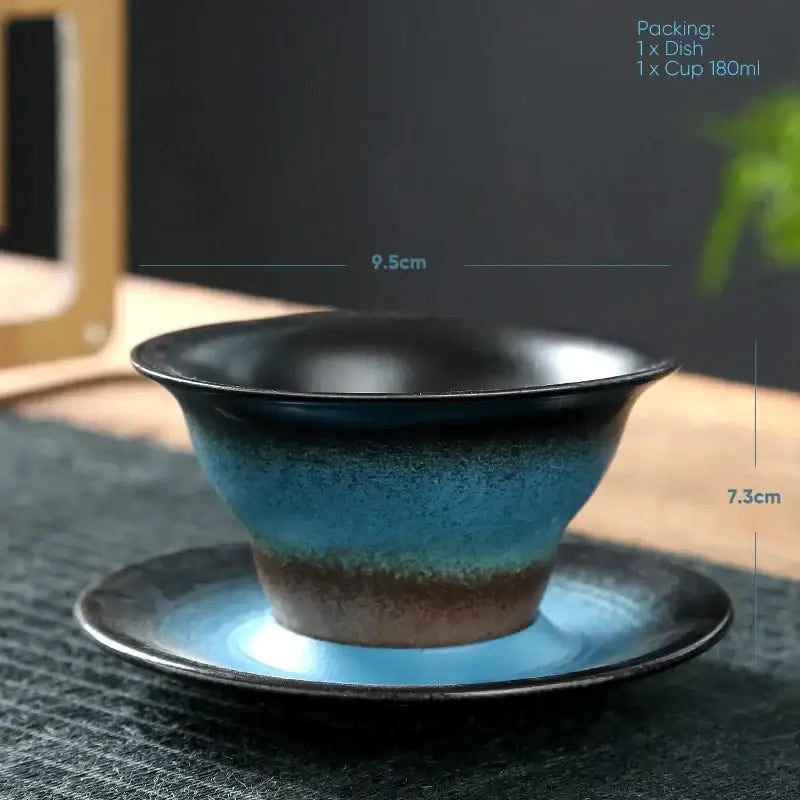 Handcrafted ceramic latte coffee cup with deep blue to black gradient glaze and matching saucer for dining room use